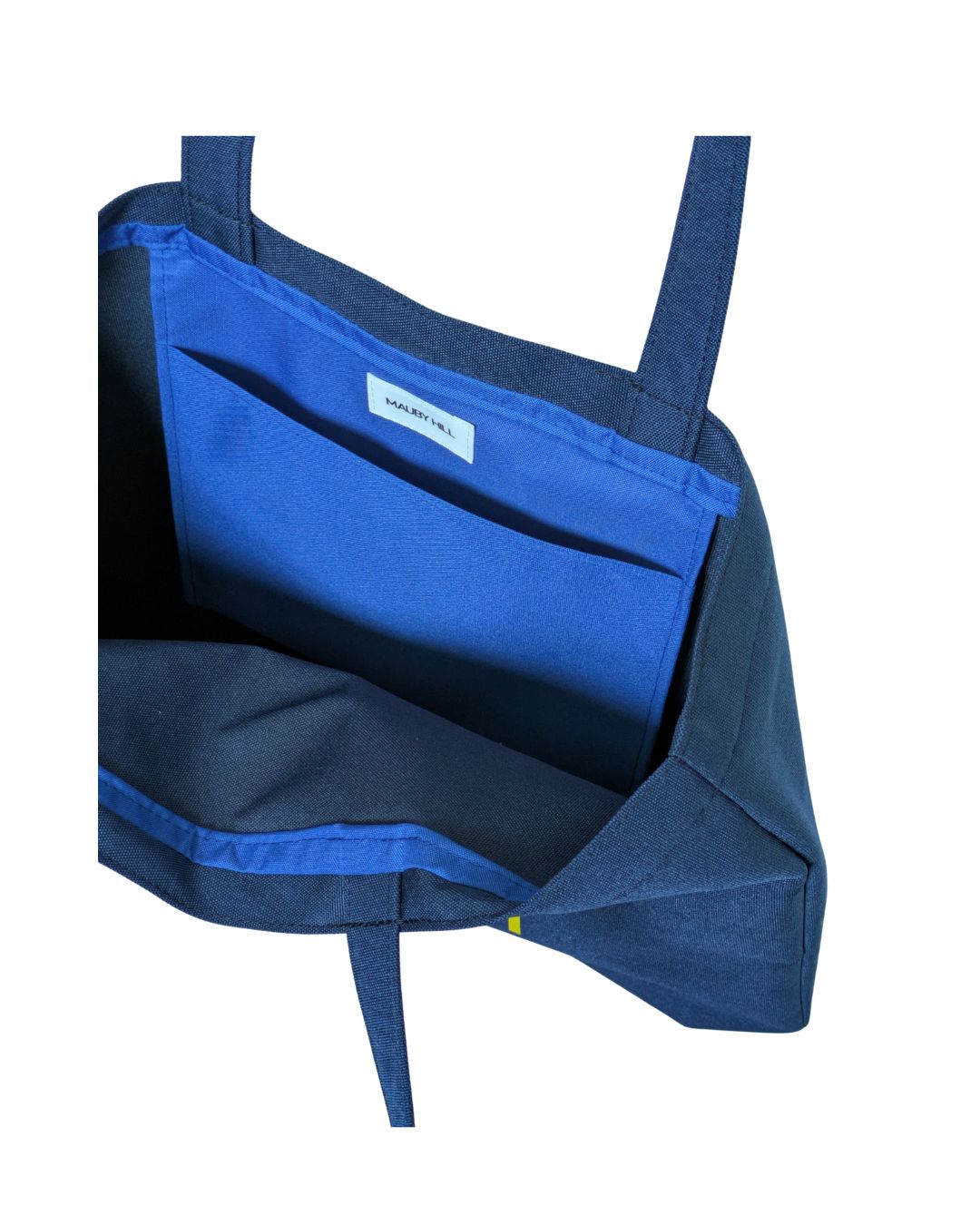 Interior view of a tote bag with a royal blue slip pocket and visible brand label on a white background